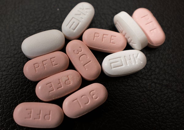 Pink and white pills on a dark background.