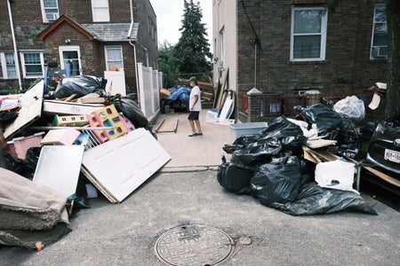 Person walking between homes damaged by hurrincane flooding..
