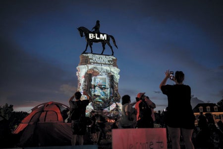 Confederate monument with BLM and the face of Frederick Douglas projected on it.