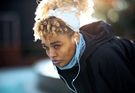 A woman listening to music with earphones.