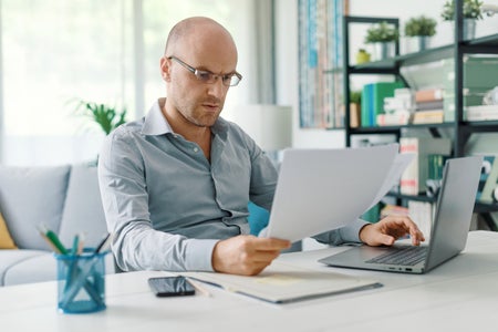 Perplexed businessman looking at paperwork