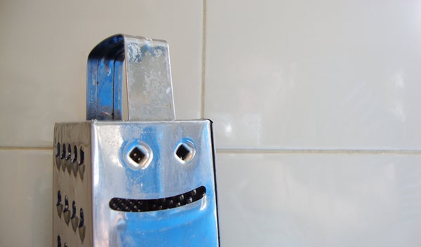 A cheese grater turned to the side appears to be a smiling face.