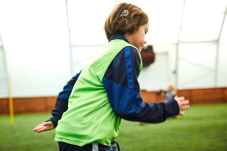 A boy, running, with a device attached to his head.