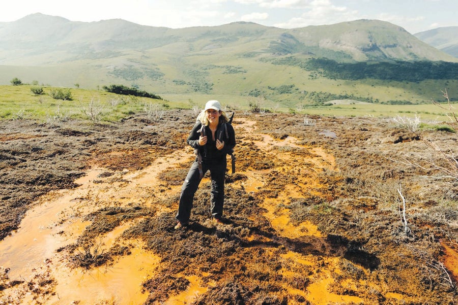Photo of Taylor Roades standing near a rust-colored river.