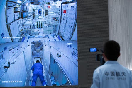 A worker watches as three Chinese astronauts enter the Tianhe module of the country's Tiangong space station.