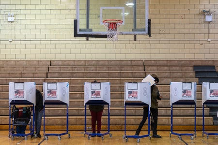 voters fill out ballots at a polling place