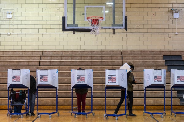voters fill out ballots at a polling place