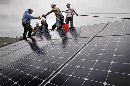 Group of men installing roof solar panels.