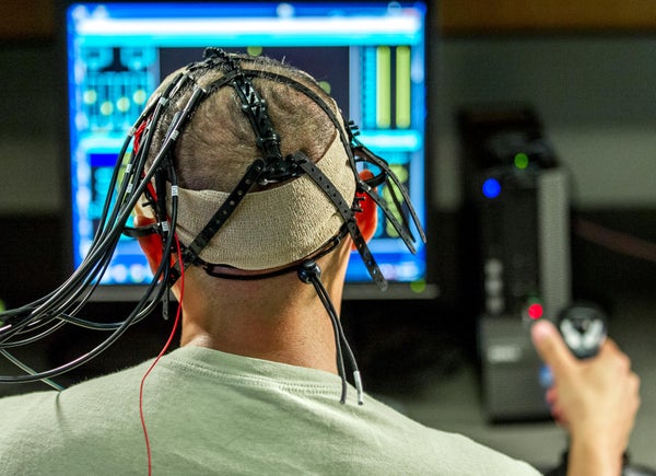 A test subject uses the Multi-Attribute Task Battery to perform a multitasking cognitive test while electrodes administer directed electrical brain stimulation.