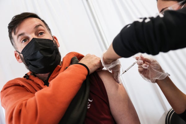 Masked patient recieves vaccine.