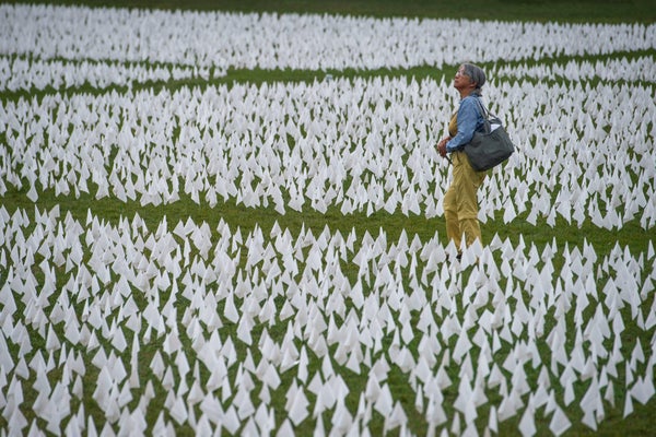 A woman in a field of small white flags.
