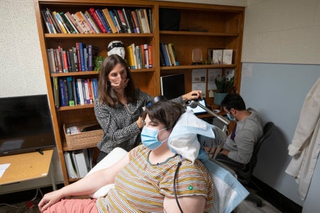 Seated patient is treated by a researcher.