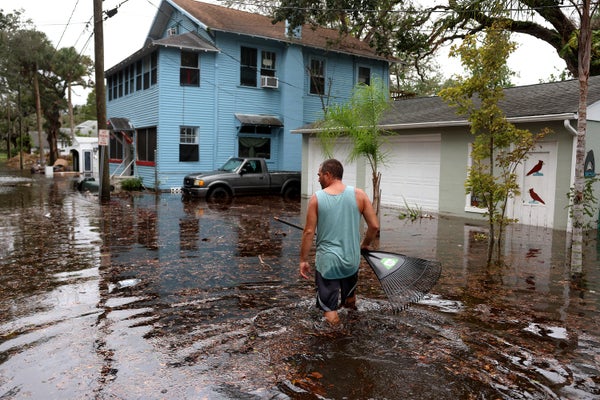 Man walking through flooded street.