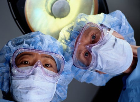 surgeons with masks on looking down