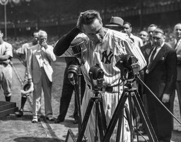 An emotional Lou Gehrig pauses while giving historic speech on baseball field.