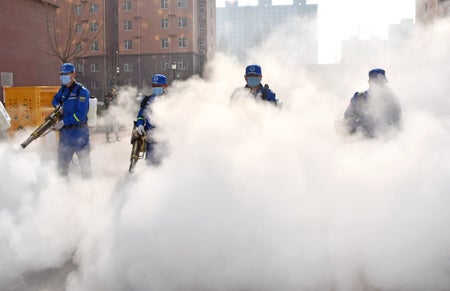 Volunteers spray disinfectant in the town in Handan city in north China's Hebei province Saturday, Jan. 23, 2021.