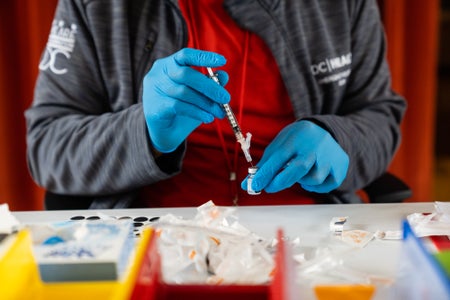 A nurse prepares a syringe with a Covid-19 vaccine