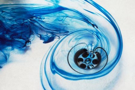 blue-tinted water flowing into a drain