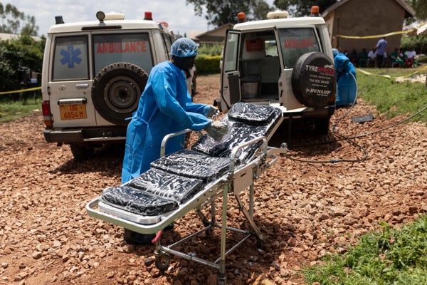 A healthcare worker washes an ambulance stretcher.