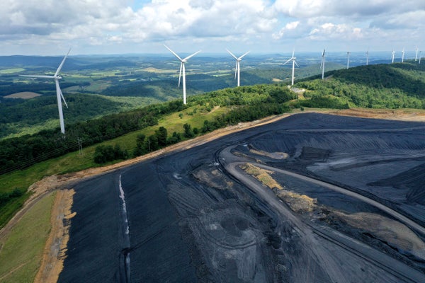 Aerial view of wind turbines behind coal field