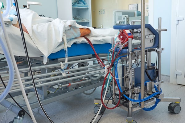An ECMO machine next to a patient's bed in a hospital's intensive care unit