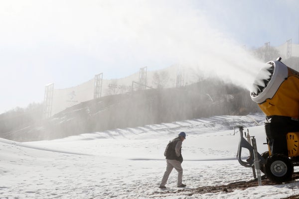 Snow machine on hillside blowing manmade snow.
