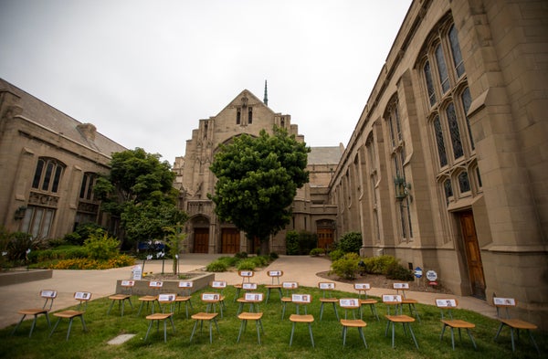 Empty chairs with names of students on them in church yard.