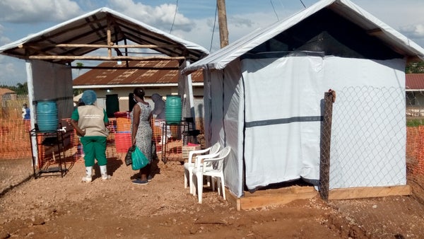 Two people standing outside a tent