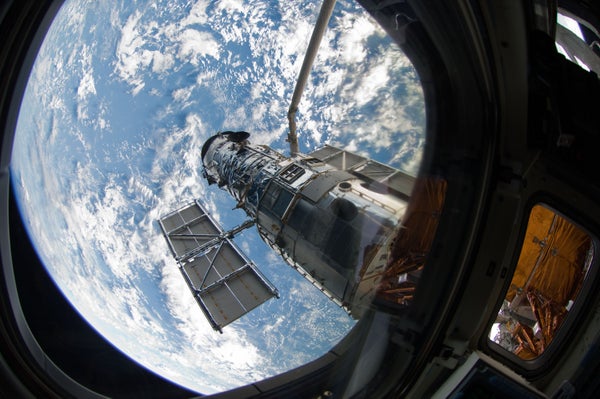 A view of the Hubble Space Telescope through a window on the space shuttle Atlantis, during the final servicing mission to the orbital observatory in 2009.