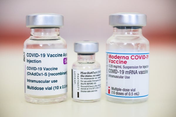 Vials of COVID vaccine with labels reading "Moderna" and "Pfizer BioNTech" clearly visible.