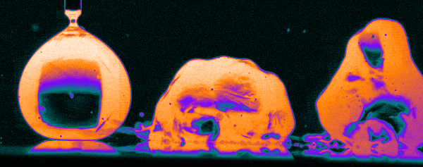 A false color image of water droplets beginning to boil on a surface.