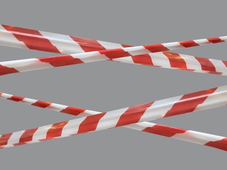 Red-and-white warning lines of barrier tape prohibit passage