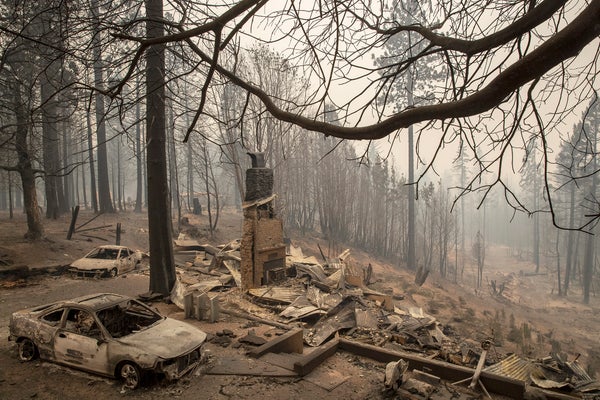 A home smolders in ruins after a wildfire.