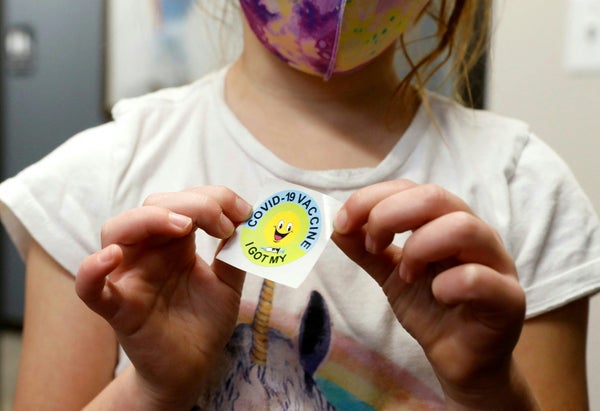 Child holding a sticker.