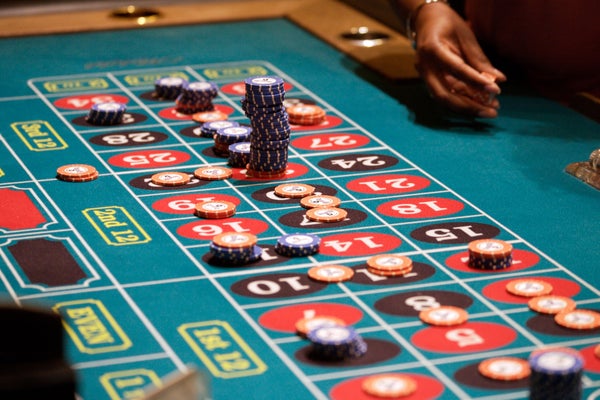 Woman's hand holding gambling chips at roulette table