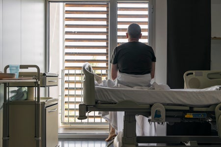 Creative Images Images Creative Editorial Video Creative Editorial  Search by image or video Unrecognisable man sits on hospital bed and looks out of the window