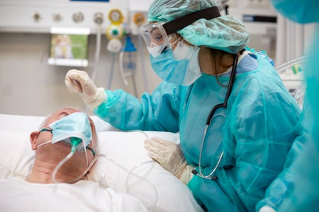 A nurse tends to a COVID patient in the ICU.