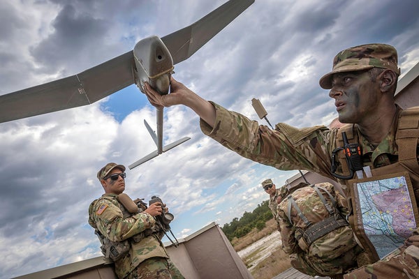 US Army members work with a small unmanned drone