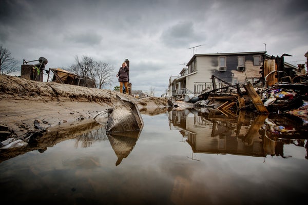 Woman walking in flooded neighborhood.