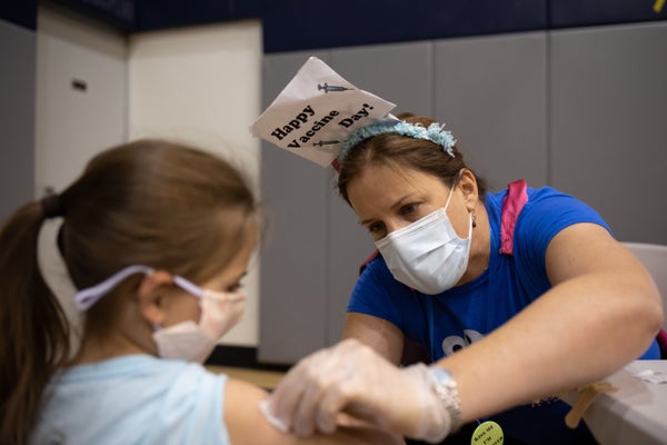 A child is prepared to receive a Covid vaccine.