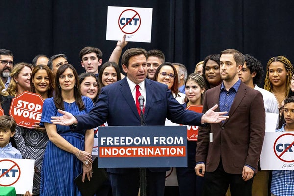 Ron DeSantis surrounded by people on stage at a rally
