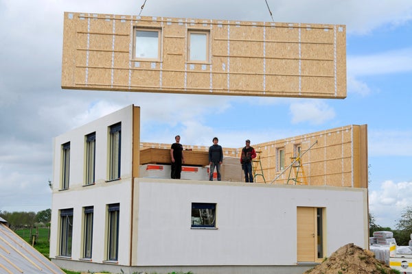 Workers standing on top of a home in the construction phase