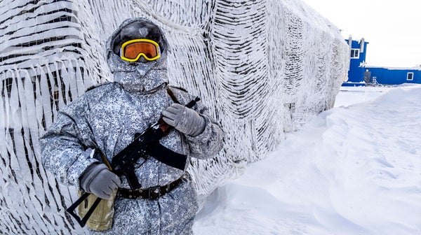 A soldier holds a machine gun in the arctic circle