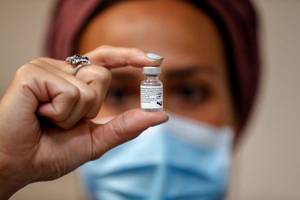 A health worker holding a Pfizer-BioNtech COVID-19 vaccine.