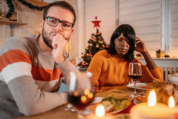 Unhappy couple ignoring each other at Christmas dinner