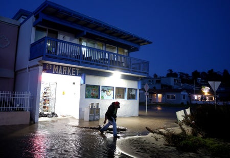 Man walking out of flooded building.
