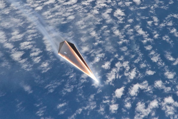 Triangular-shaped missile flies above white clouds.