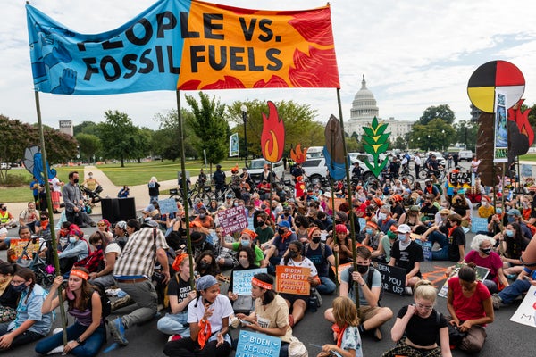 Demonstrators sit in an intersection during a climate change rally with sigh People Stop Fossil Fuel