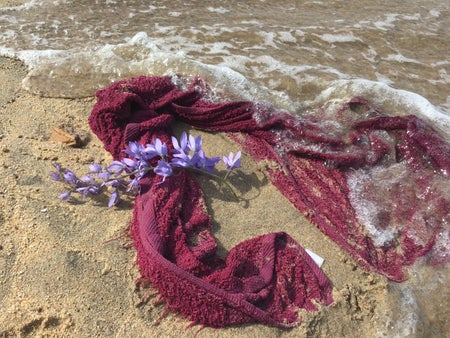 Violet wisteria flowers resting on a purple towel.