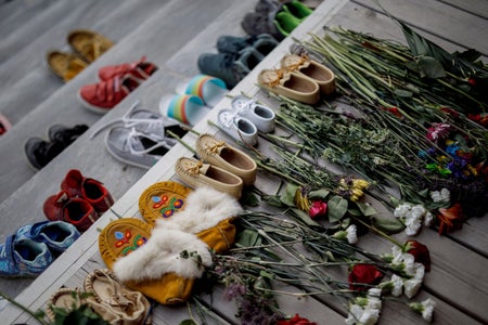 Flowers, shoes and moccasins sit on stairs.